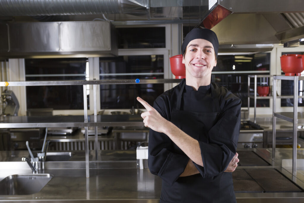 Happy chef pointing at HVAC pros exhaust fan installation