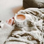 woman enjoying cup of coffee in her warm home by Hutchinson HVAC Professionals